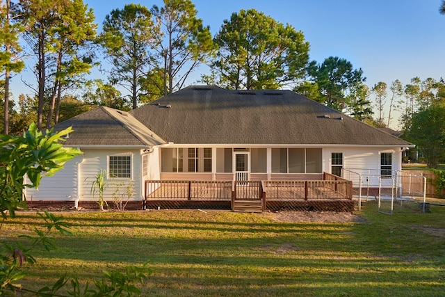 back of house with a lawn, a sunroom, and a deck