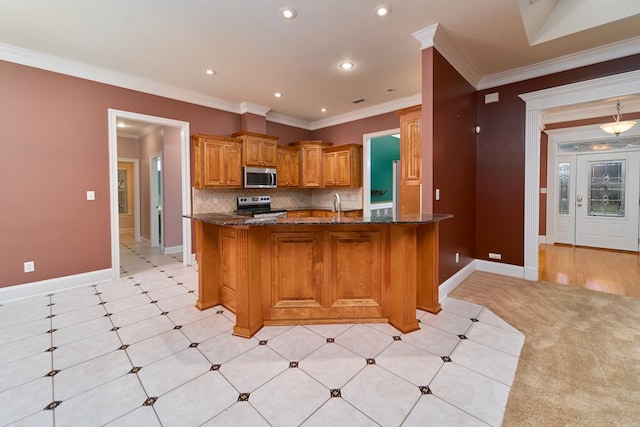 kitchen with backsplash, dark stone counters, ornamental molding, appliances with stainless steel finishes, and kitchen peninsula