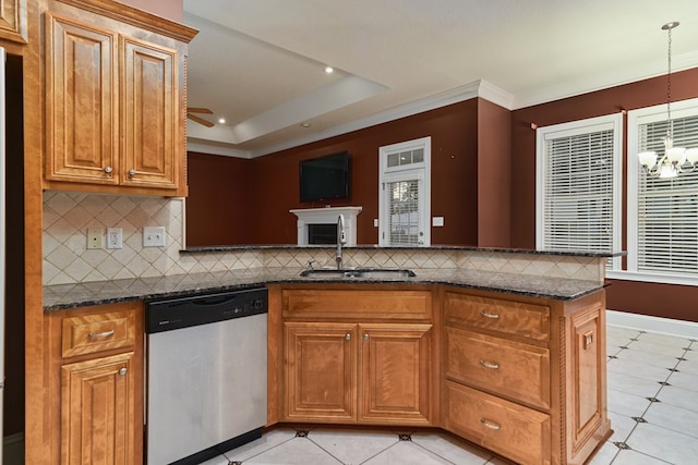 kitchen featuring decorative backsplash, stainless steel dishwasher, dark stone counters, sink, and decorative light fixtures