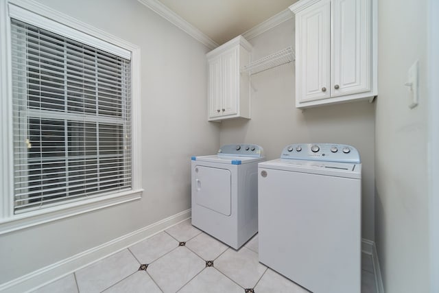 clothes washing area featuring light tile patterned flooring, cabinets, ornamental molding, and washing machine and dryer