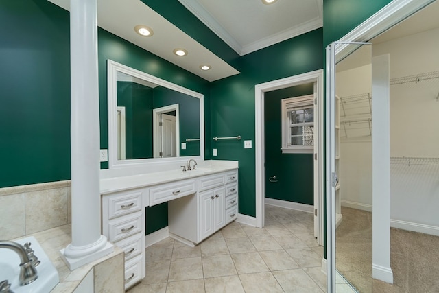 bathroom with crown molding, tile patterned flooring, vanity, and a relaxing tiled tub