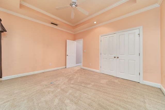 unfurnished bedroom featuring a raised ceiling, ceiling fan, and ornamental molding