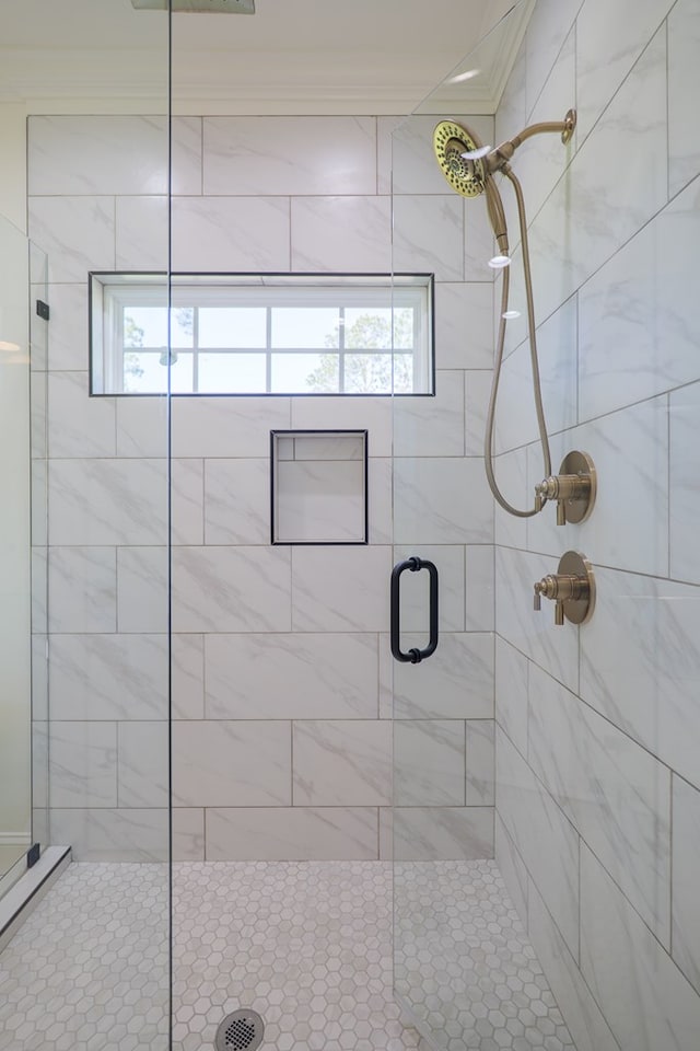 full bathroom with crown molding and a shower stall