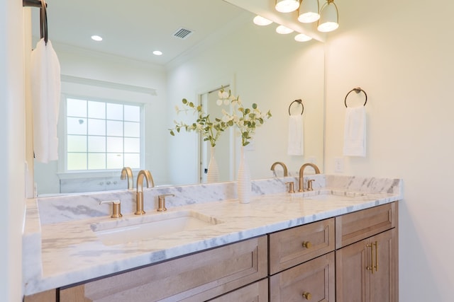 full bathroom with double vanity, visible vents, a sink, and ornamental molding