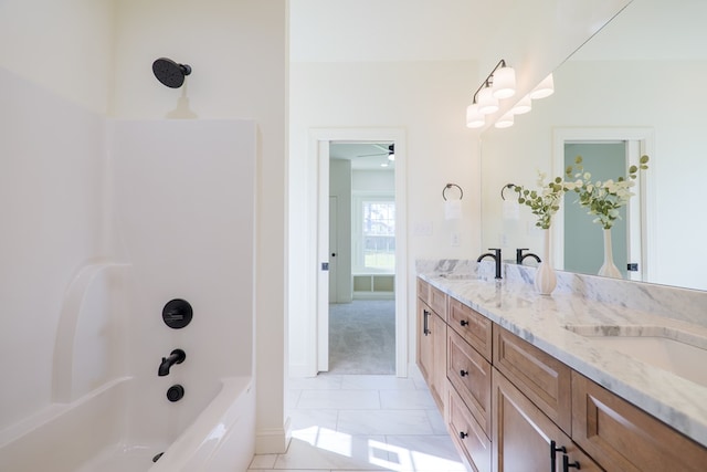 bathroom with a sink, ceiling fan, shower / bathing tub combination, double vanity, and tile patterned flooring