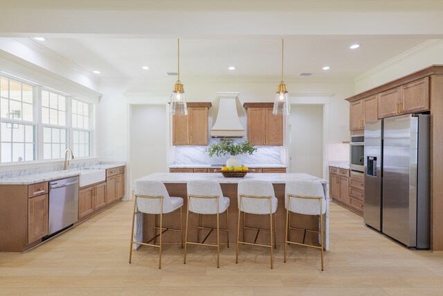 kitchen featuring custom range hood, crown molding, a kitchen island, stainless steel appliances, and a sink