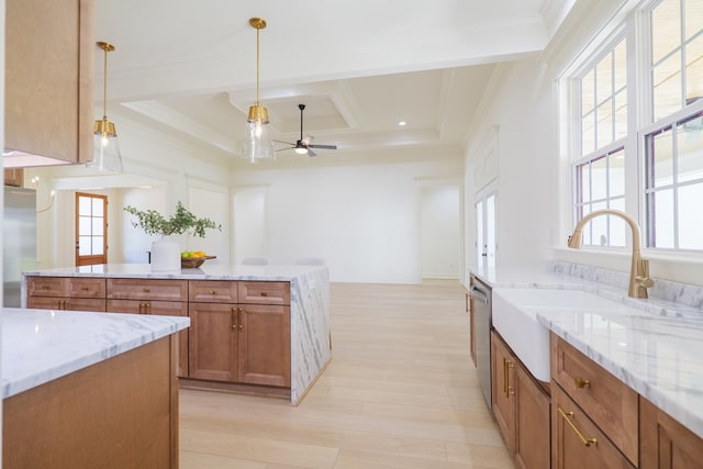 kitchen with crown molding, a ceiling fan, a sink, stainless steel appliances, and brown cabinets