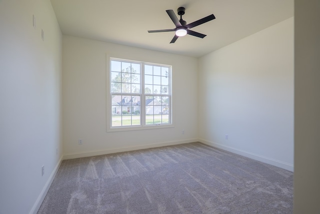 spare room featuring ceiling fan, baseboards, and carpet