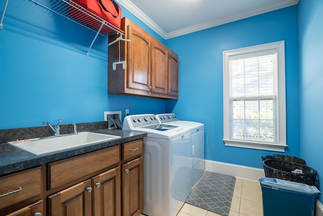 washroom with cabinets, washing machine and clothes dryer, sink, ornamental molding, and light tile patterned floors