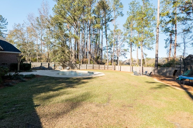 view of yard featuring a trampoline and a fenced in pool