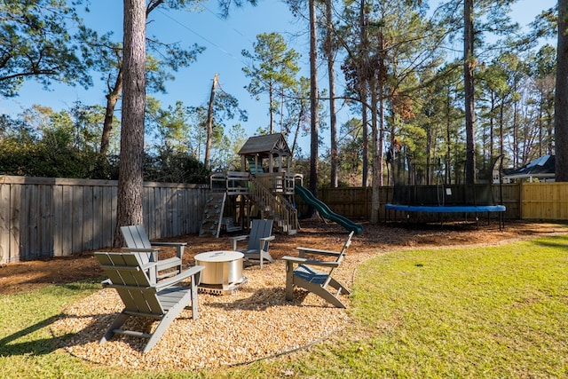 view of yard featuring a trampoline and a playground