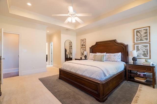 carpeted bedroom featuring ceiling fan, crown molding, and a raised ceiling