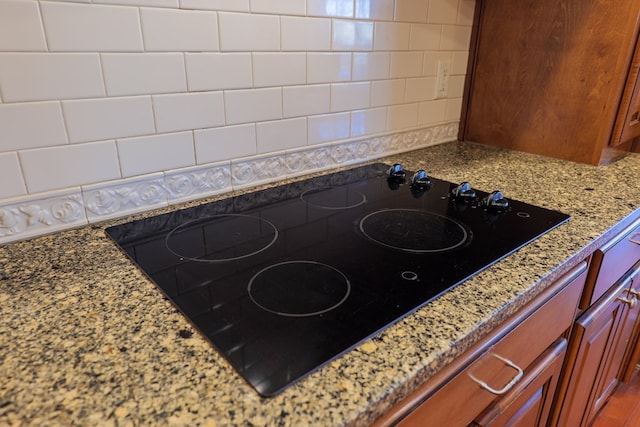 room details with light stone counters and black electric cooktop