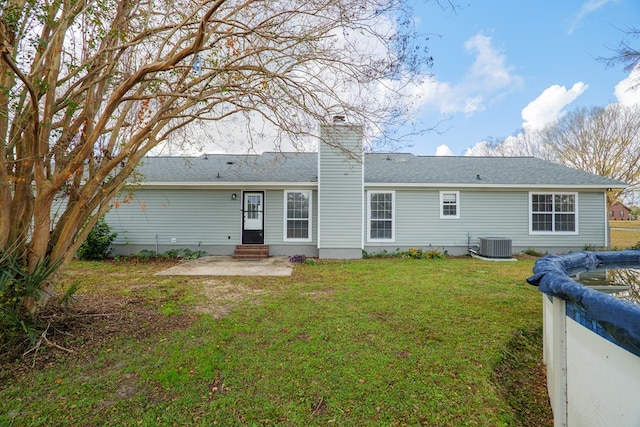 back of house with a lawn and central AC unit