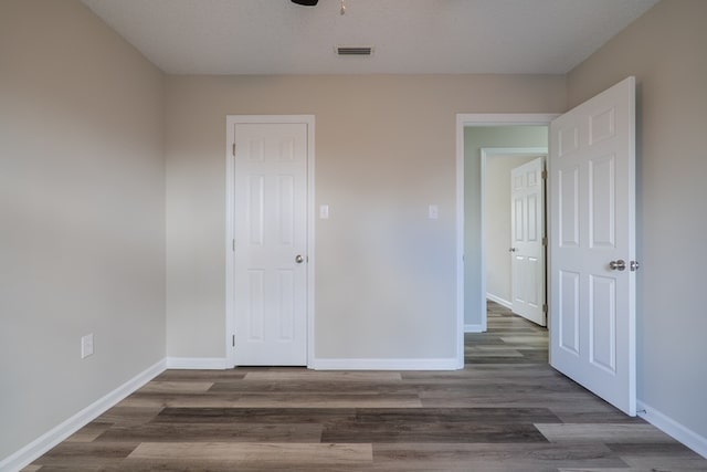 unfurnished bedroom featuring dark hardwood / wood-style floors and a textured ceiling