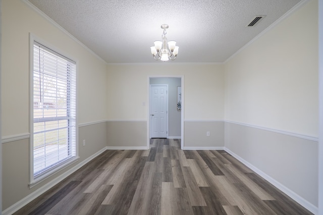 unfurnished room with dark hardwood / wood-style flooring, plenty of natural light, a textured ceiling, and a notable chandelier