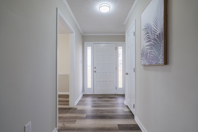 entrance foyer with dark hardwood / wood-style floors, ornamental molding, and a textured ceiling