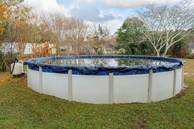 view of swimming pool with a yard