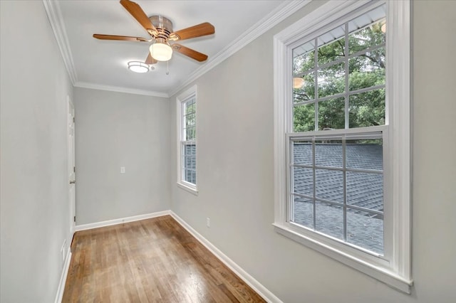 spare room featuring a wealth of natural light, ornamental molding, and hardwood / wood-style flooring