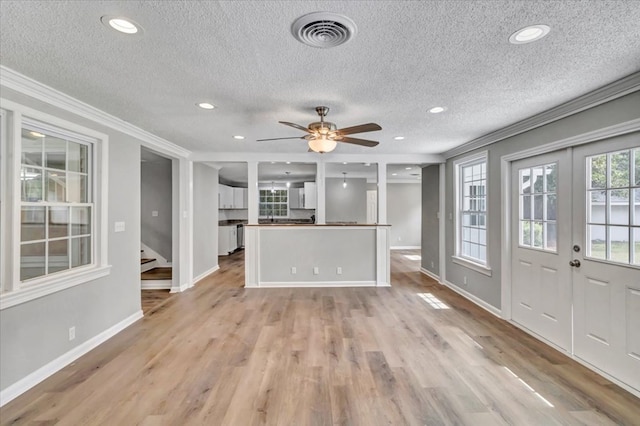 unfurnished living room featuring a textured ceiling, light hardwood / wood-style flooring, and ornamental molding