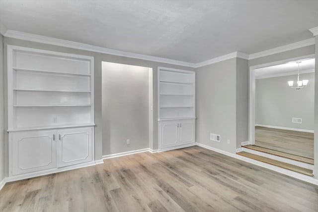 interior space featuring a notable chandelier, built in shelves, ornamental molding, and light hardwood / wood-style flooring