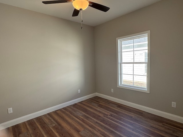 unfurnished room featuring dark wood-type flooring, ceiling fan, and baseboards