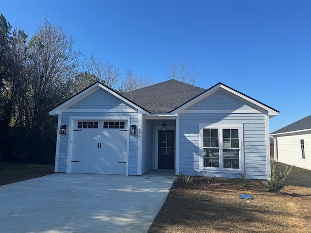 ranch-style home featuring roof with shingles, driveway, and an attached garage