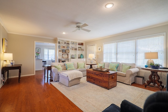 living room with wood-type flooring, ornamental molding, and a textured ceiling