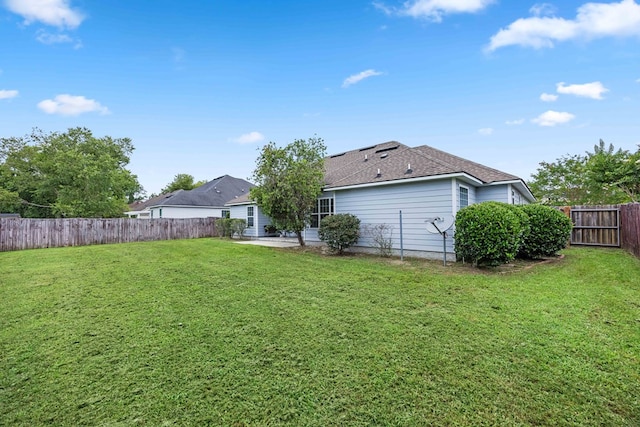 5221 Carys Brook Dr, Hahira, GA 31632 - rear view of house featuring a fenced backyard, a patio, and a shingled roof