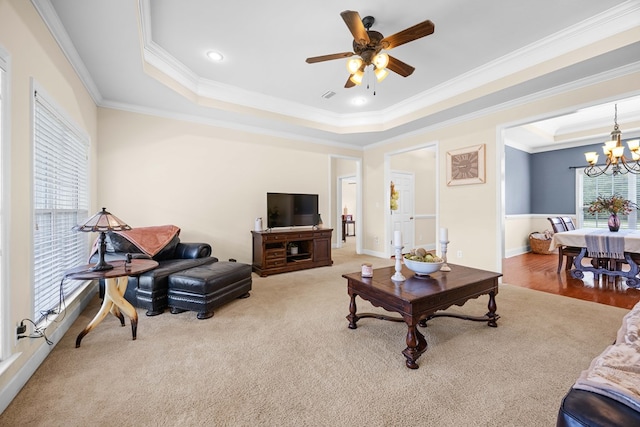 5221 Carys Brook Dr, Hahira, GA 31632 - living room featuring a tray ceiling, crown molding, a chandelier, a ceiling fan, and light colored carpet