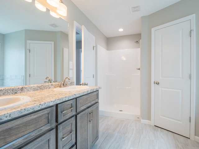 bathroom featuring a shower and vanity