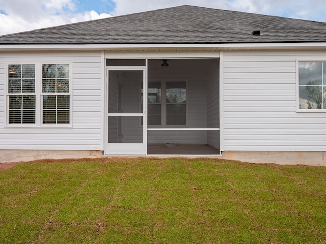 rear view of house with a sunroom and a yard