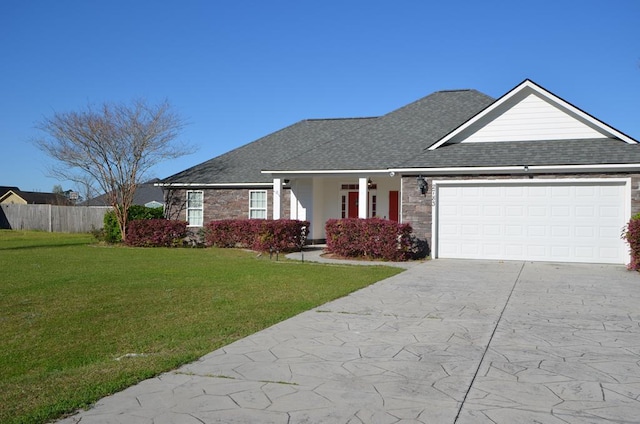 ranch-style home with fence, an attached garage, a shingled roof, a front lawn, and concrete driveway