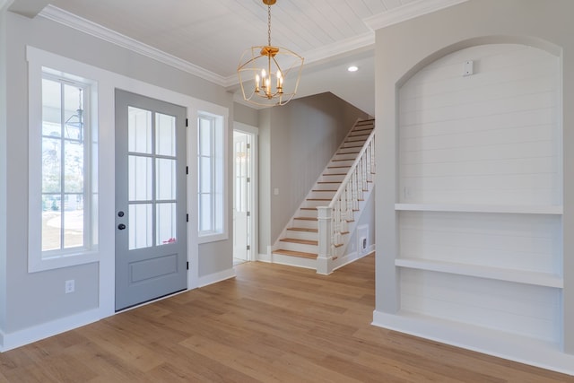 foyer entrance with crown molding, beam ceiling, light hardwood / wood-style floors, and a notable chandelier