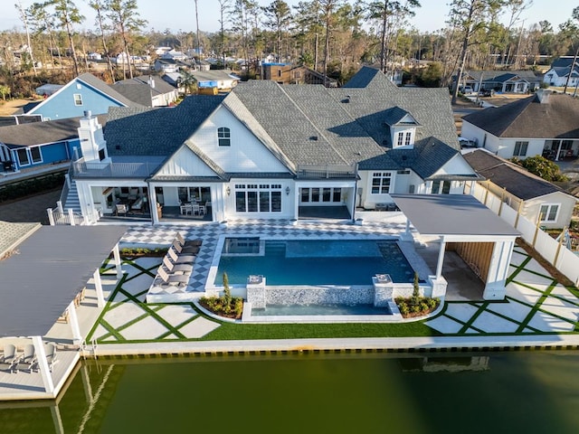 back of property featuring a water view and a patio area