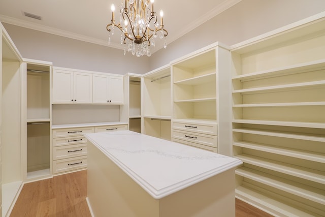 walk in closet with light hardwood / wood-style flooring