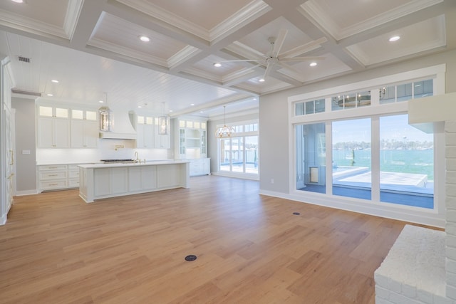 unfurnished living room featuring beamed ceiling, crown molding, coffered ceiling, and light hardwood / wood-style flooring