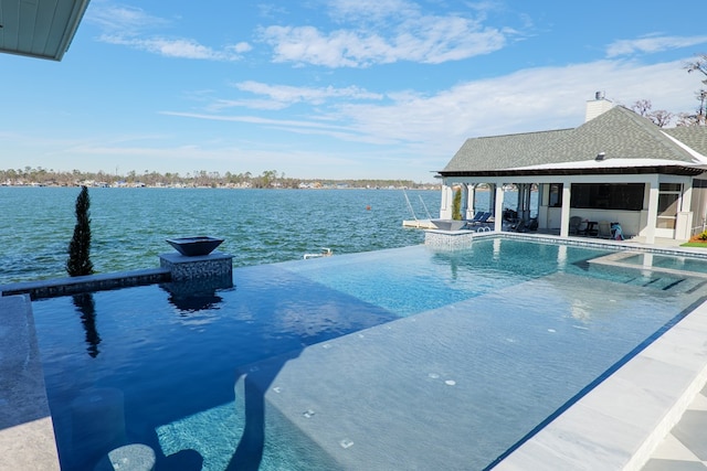 view of swimming pool with a patio area and a water view