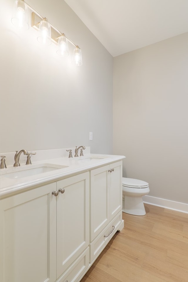 bathroom featuring vanity, wood-type flooring, and toilet