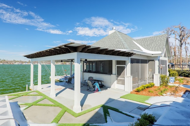 view of patio featuring a sunroom and a water view