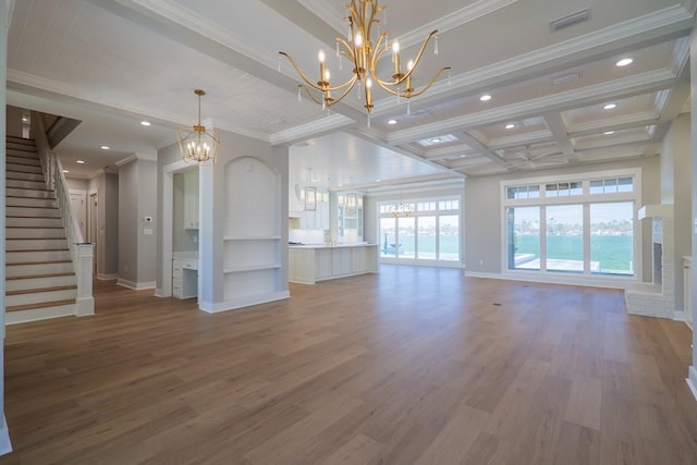 unfurnished living room with an inviting chandelier, crown molding, and hardwood / wood-style flooring