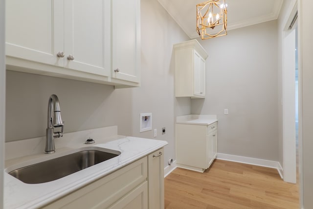 clothes washing area with sink, crown molding, cabinets, hookup for a washing machine, and hookup for an electric dryer