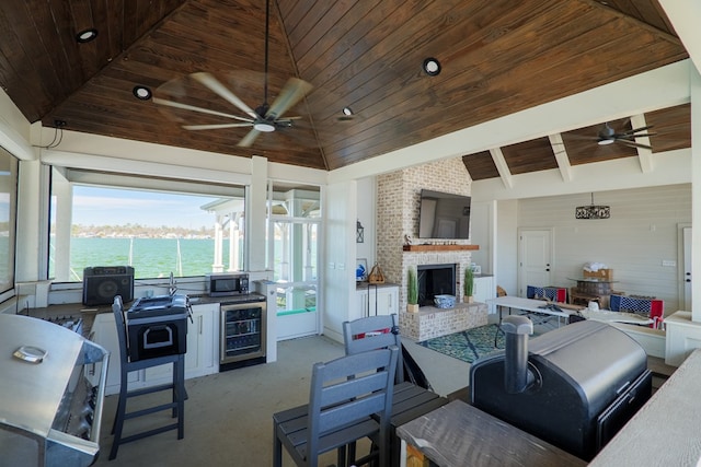 interior space with ceiling fan, beverage cooler, a fireplace, and area for grilling