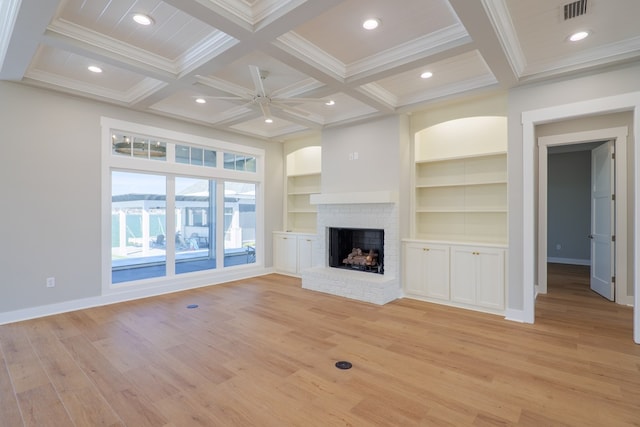 unfurnished living room with coffered ceiling, beam ceiling, a fireplace, and built in features