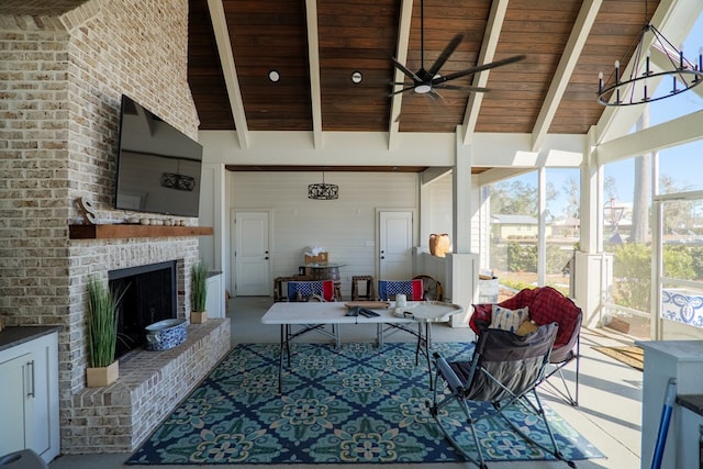 sunroom / solarium featuring lofted ceiling with beams, a brick fireplace, wooden ceiling, and ceiling fan