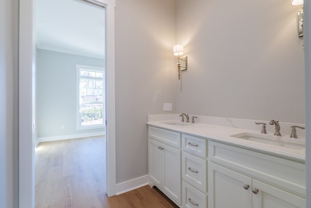 bathroom with vanity, crown molding, and wood-type flooring