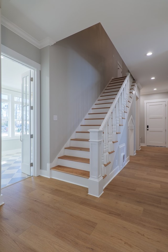 stairs with crown molding and hardwood / wood-style floors