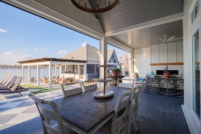 view of patio with a water view, ceiling fan, and a pergola