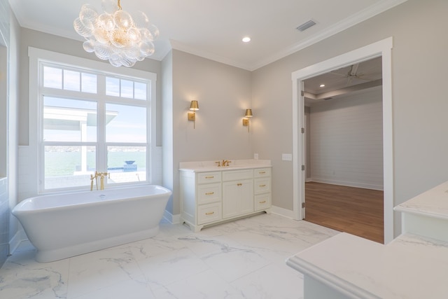 bathroom featuring a notable chandelier, crown molding, a washtub, and vanity