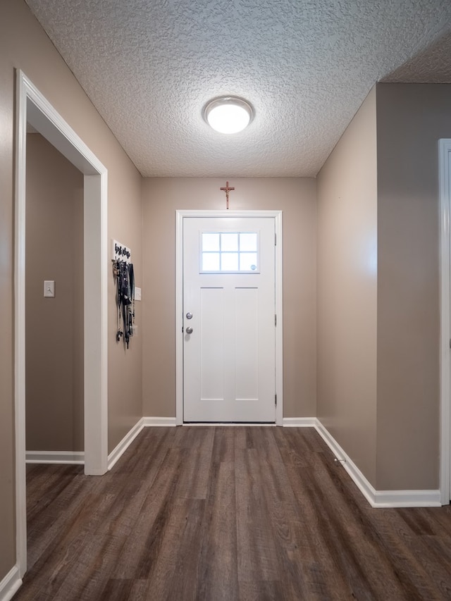 entryway with dark wood-style floors, baseboards, and a textured ceiling